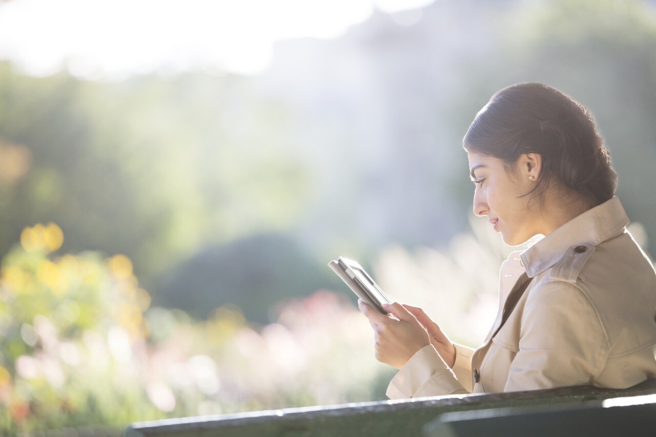 Businesswoman using digital tablet in park