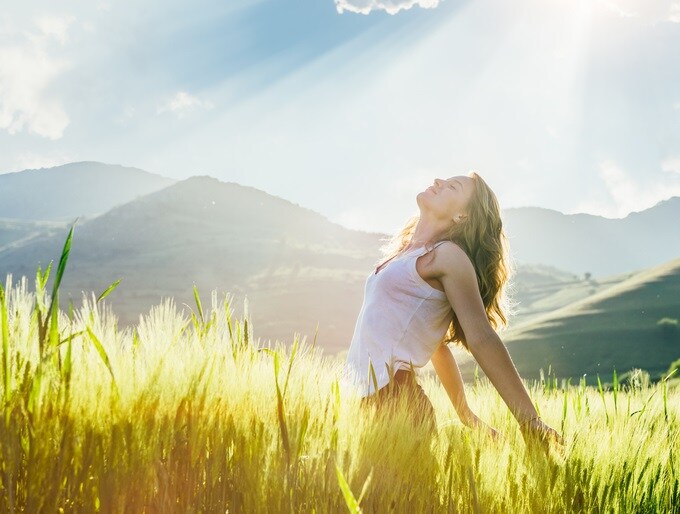 young woman in the wheat field enjoying the sun